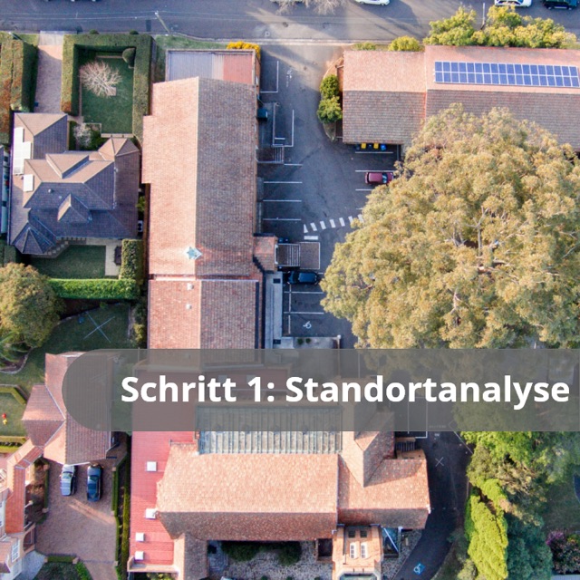 Schritt 1: Standortanalyse. Luftbild eines Wohngebiets mit Satteldaechern, aufgenommen per Drohne