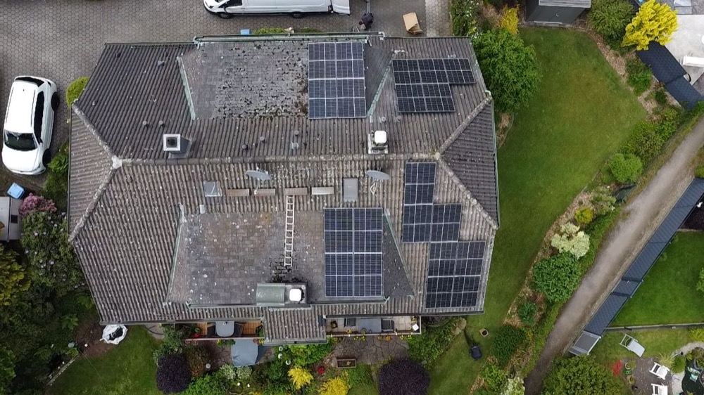 Einfamilienhaus mit Photovoltaikanlage auf mehreren Dachflächen, Luftaufnahme